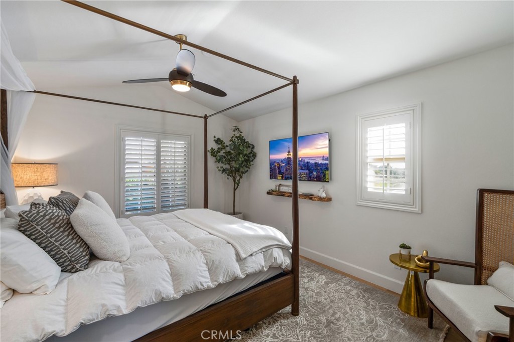 33 Cassis Dana Point, CA 92629 - Photo 18 of 49 a bedroom with a bed a chandelier and a flat screen tv