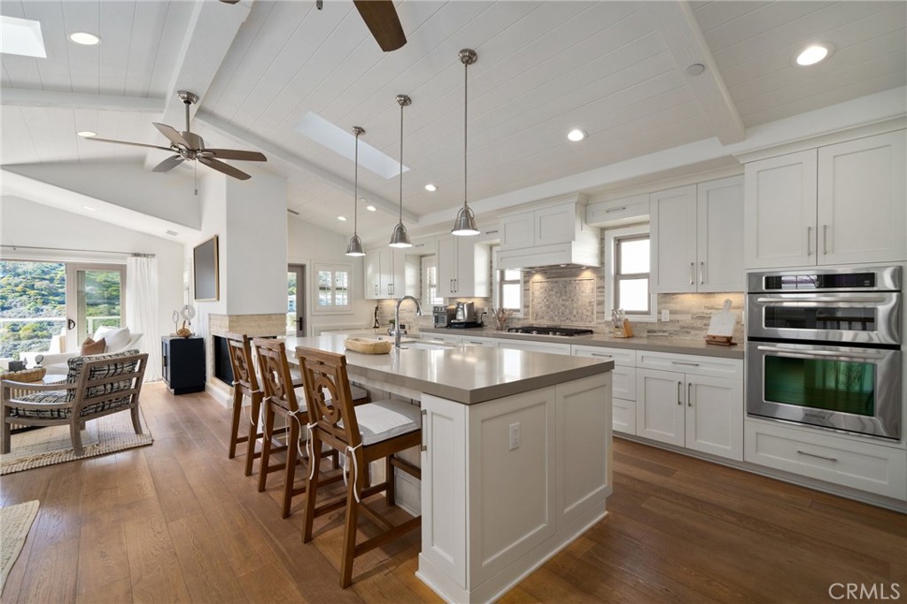 33 Cassis Dana Point, CA 92629 - Photo 6 of 49 a kitchen with stainless steel appliances a dining table chairs stove and white cabinets