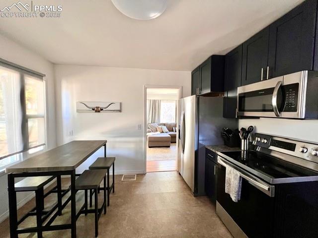 1819 East Yampa Street Colorado Springs, CO 80909 - Photo 11 of 25 a kitchen with stainless steel appliances a stove a sink a microwave a refrigerator and cabinets
