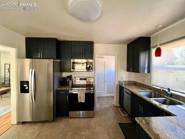 a kitchen with stainless steel appliances granite countertop a refrigerator and a stove