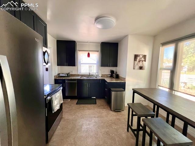 1819 East Yampa Street Colorado Springs, CO 80909 - Photo 7 of 25 a kitchen with stainless steel appliances kitchen island granite countertop a stove a sink and a refrigerator