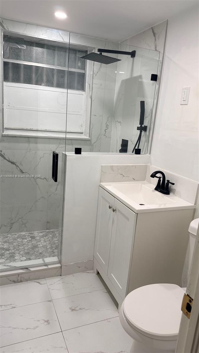 7712 Byron Avenue, Unit 2 Miami Beach, FL 33141 - Photo 16 of 24 a bathroom with a sink a toilet and shower
