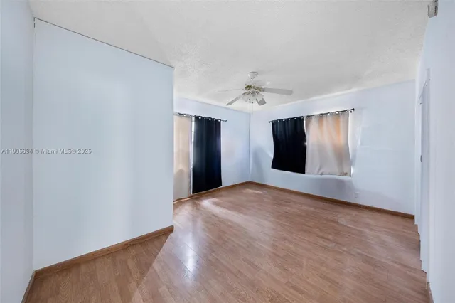 a view of an empty room with window and closet area