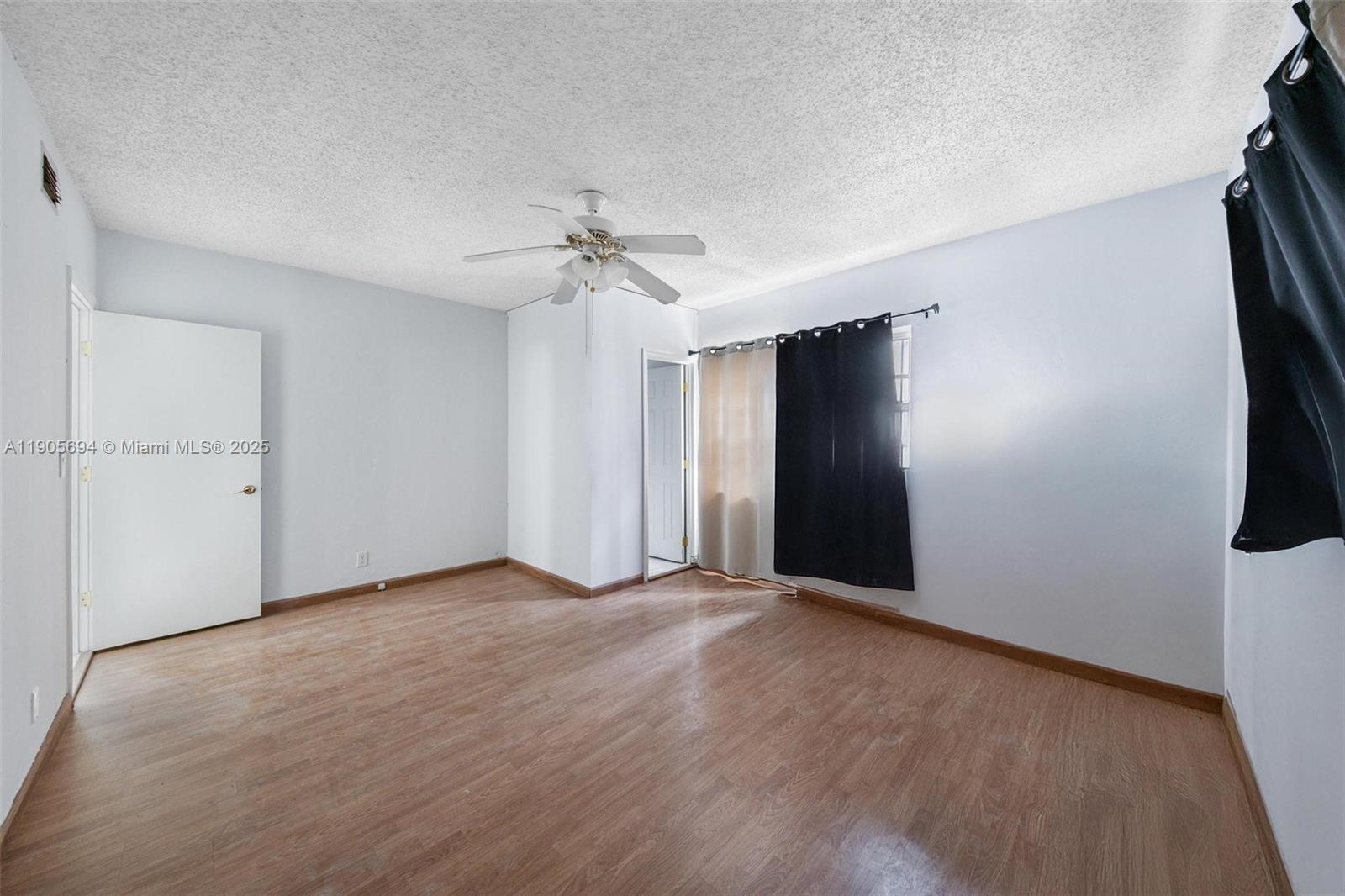 7712 Byron Avenue, Unit 2 Miami Beach, FL 33141 - Photo 19 of 24 an empty room with windows and fan