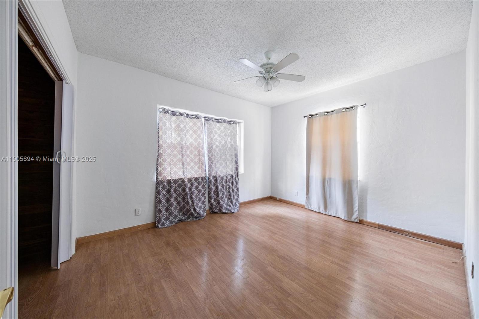 7712 Byron Avenue, Unit 2 Miami Beach, FL 33141 - Photo 21 of 24 a view of an empty room with wooden floor and a window
