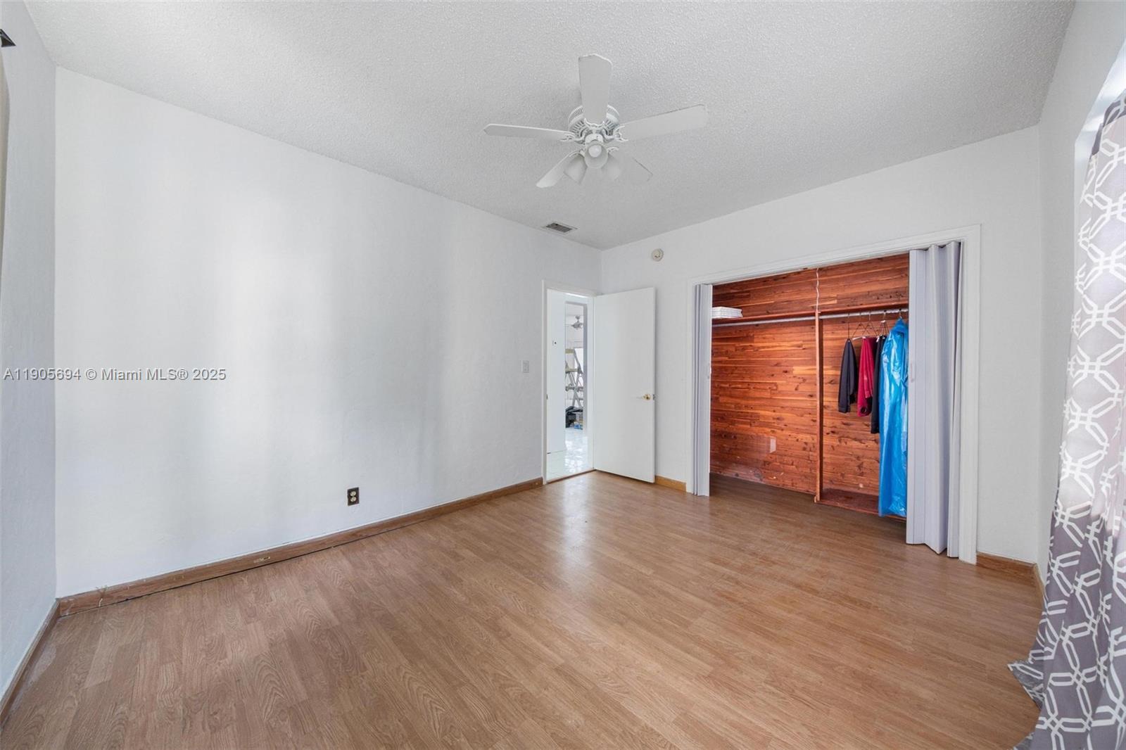 7712 Byron Avenue, Unit 2 Miami Beach, FL 33141 - Photo 23 of 24 an empty room with wooden floor closet and windows