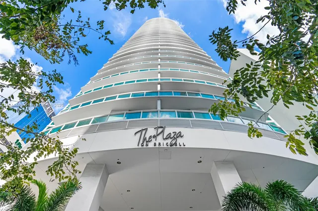 a front view of multi story residential apartment building with yard and sign board