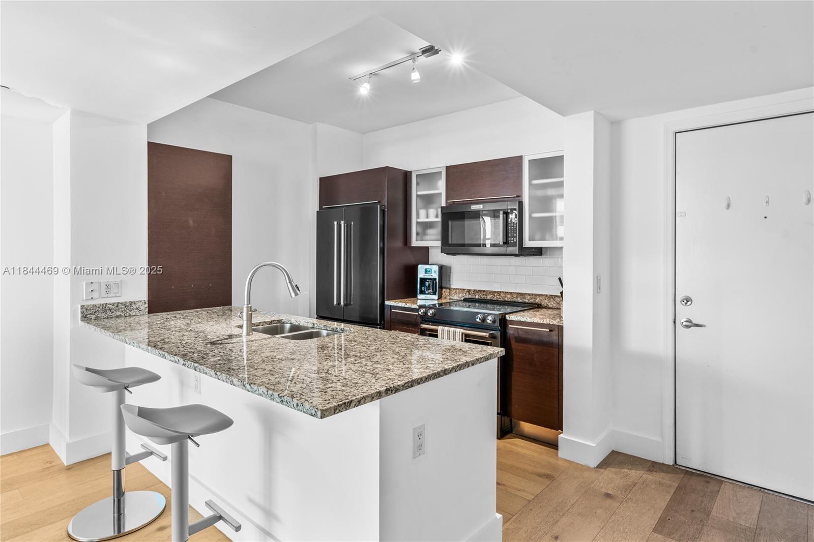 951 Brickell Avenue, Unit 1505 Miami, FL 33131 - Photo 12 of 48 a kitchen with stainless steel appliances granite countertop a sink refrigerator and cabinets