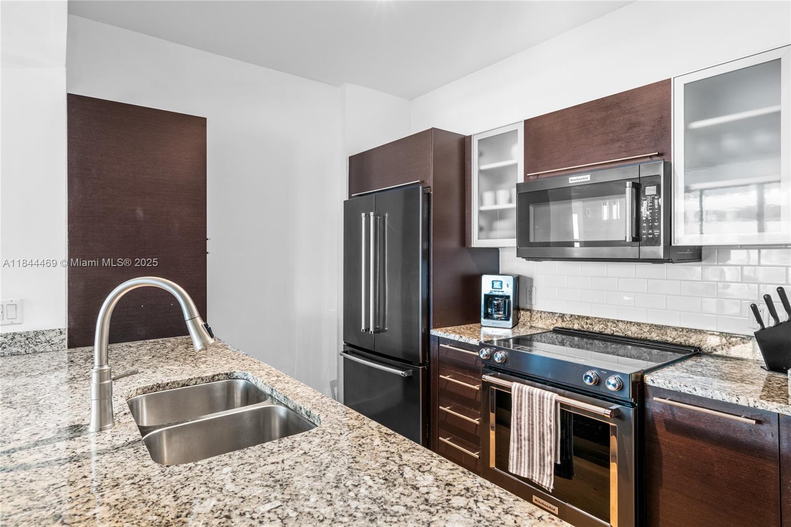 951 Brickell Avenue, Unit 1505 Miami, FL 33131 - Photo 13 of 48 a kitchen with granite countertop stainless steel appliances and a sink