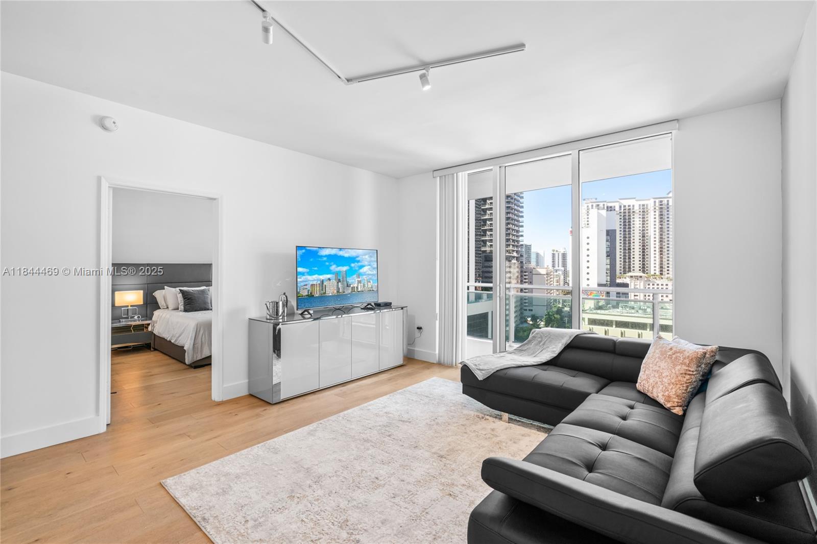 951 Brickell Avenue, Unit 1505 Miami, FL 33131 - Photo 18 of 48 a living room with furniture and a flat screen tv