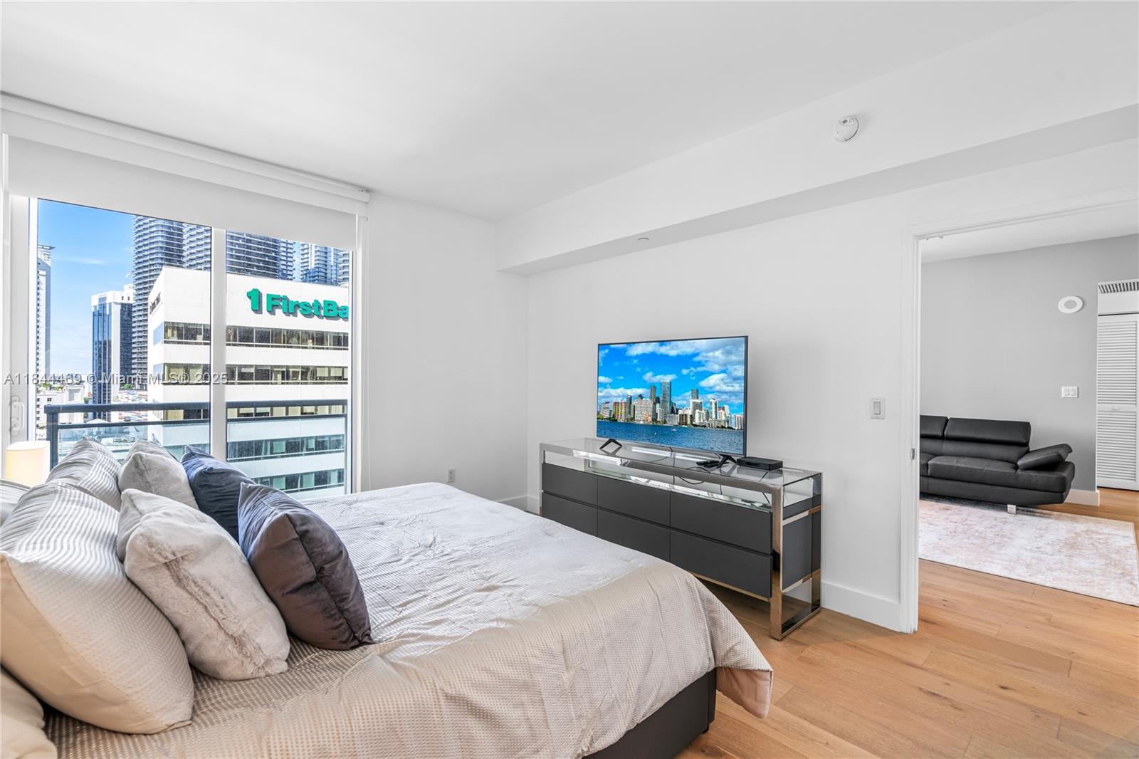 951 Brickell Avenue, Unit 1505 Miami, FL 33131 - Photo 23 of 48 a bedroom with a bed a couch and a flat screen tv