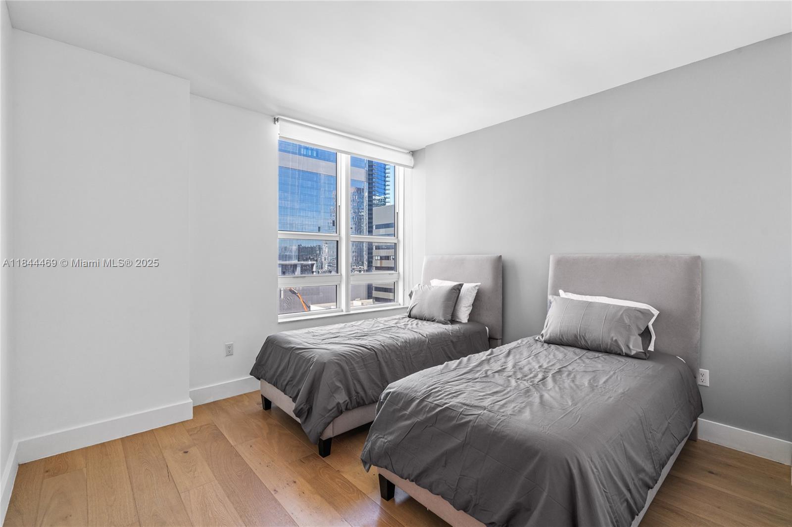 951 Brickell Avenue, Unit 1505 Miami, FL 33131 - Photo 32 of 48 a bedroom with two beds and a window
