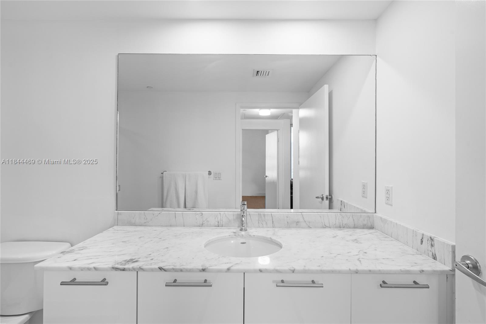 951 Brickell Avenue, Unit 1505 Miami, FL 33131 - Photo 37 of 48 a bathroom with a granite countertop sink and a mirror