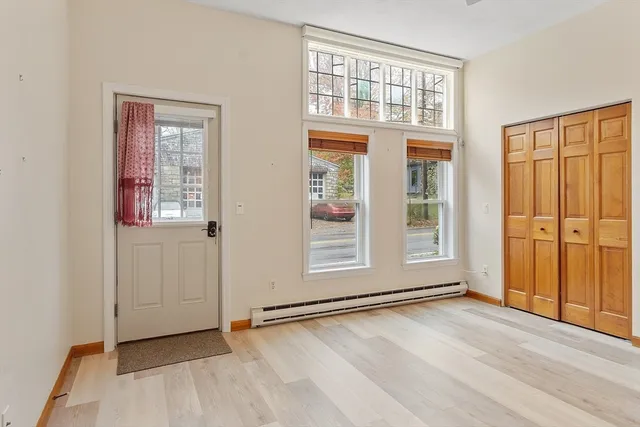 an empty room with wooden floor and windows