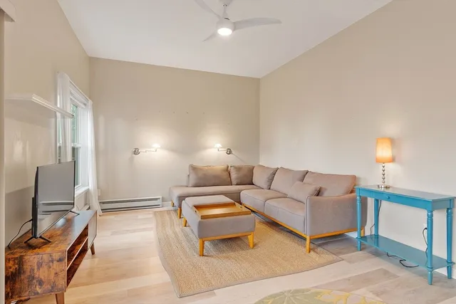 a living room with furniture a lamp and a flat screen tv