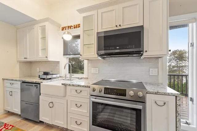 a kitchen with cabinets stainless steel appliances and a sink