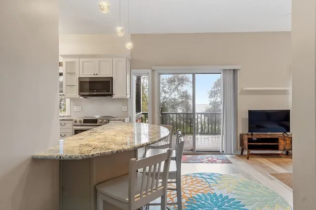 a kitchen with kitchen island granite countertop a sink and a stove