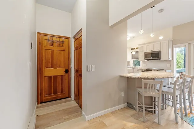 a kitchen with kitchen island granite countertop wooden cabinets and refrigerator