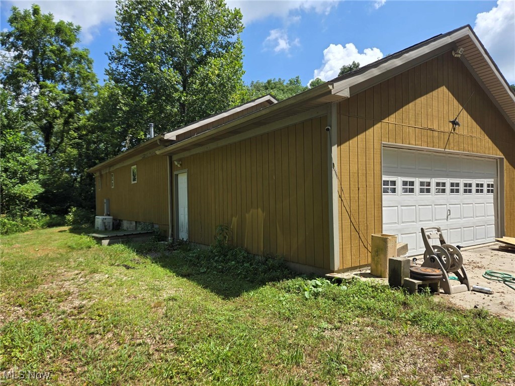 9950 North Greer Road McConnelsville, OH 43756 - Photo 1 of 1 View of side of home with a lawn and a detached garage