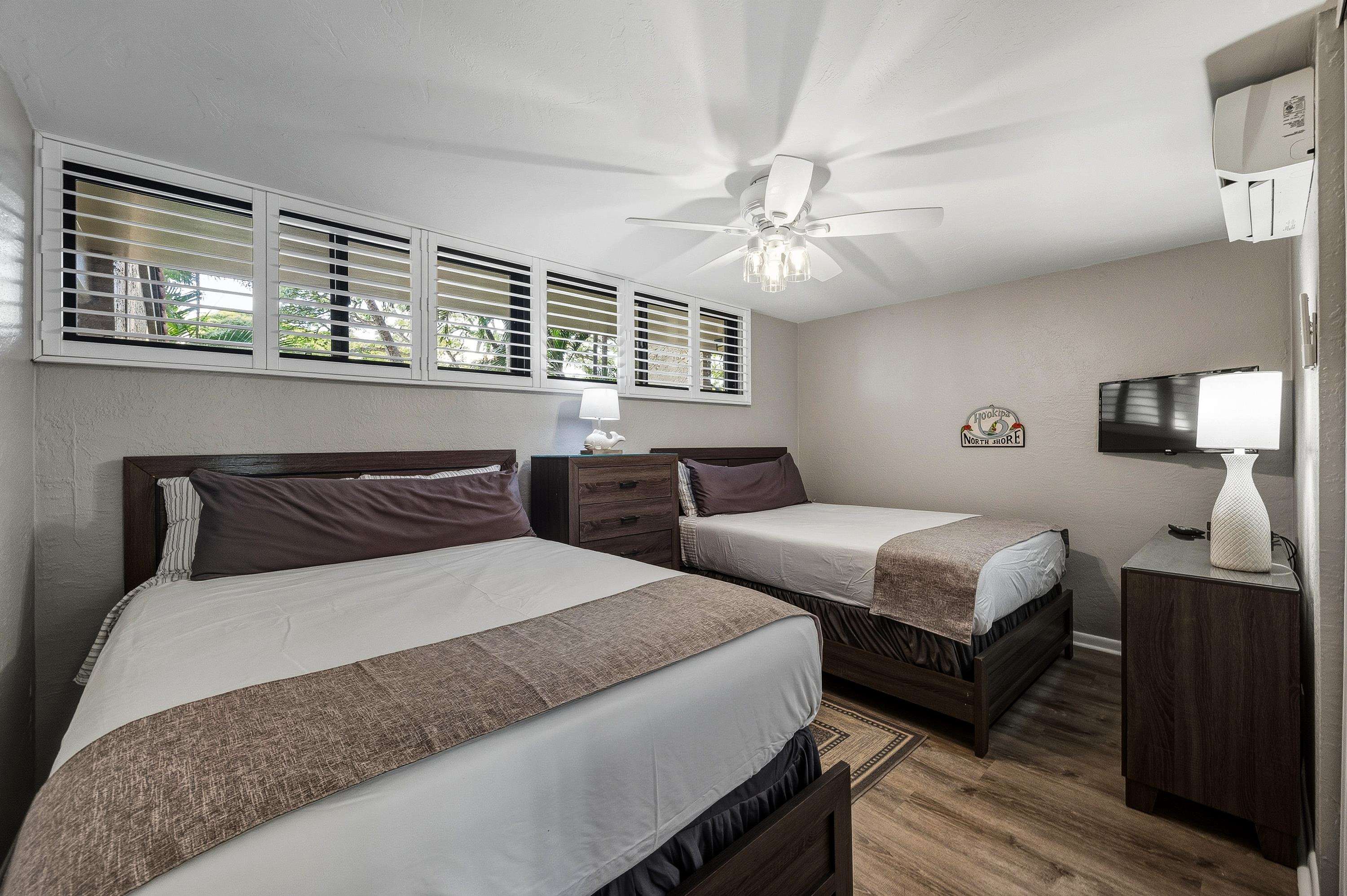 3543 Lower Honoapiilani Road, Unit H103 Lahaina, HI 96761 - Photo 14 of 50 a bedroom with a large bed and a chandelier