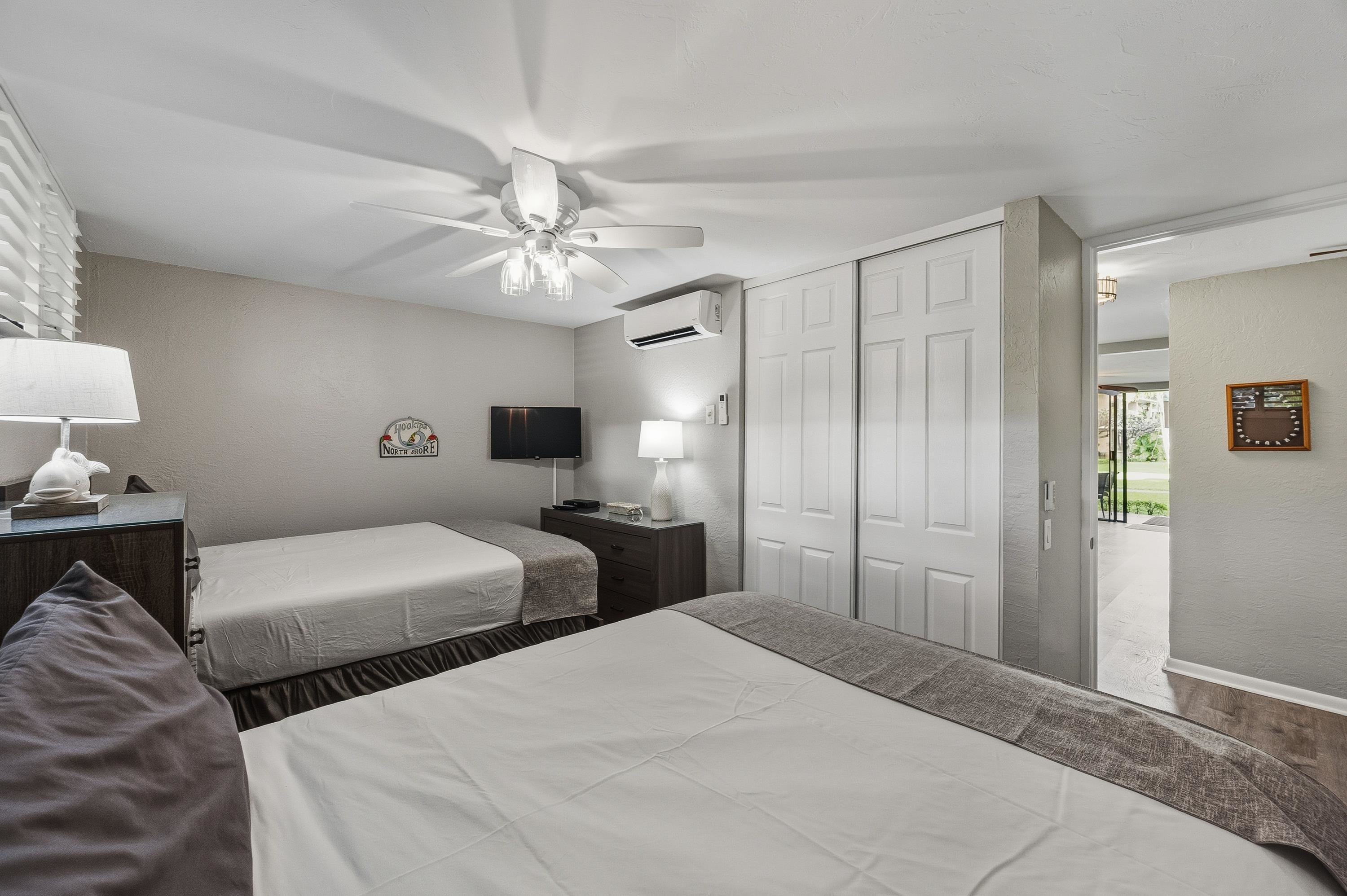 3543 Lower Honoapiilani Road, Unit H103 Lahaina, HI 96761 - Photo 16 of 50 a bedroom with two beds and a chandelier