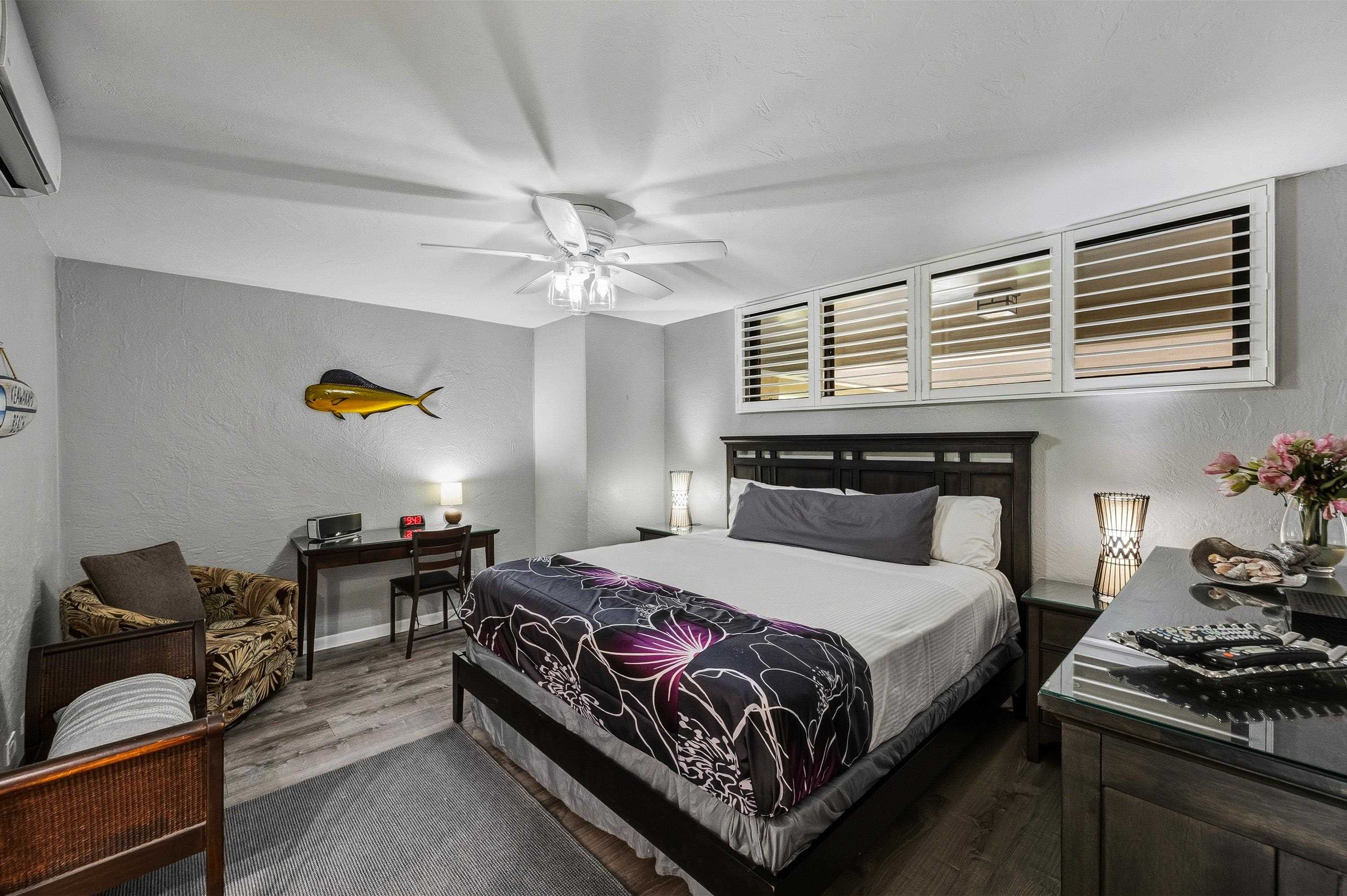 3543 Lower Honoapiilani Road, Unit H103 Lahaina, HI 96761 - Photo 24 of 50 a bedroom with a bed and a chandelier