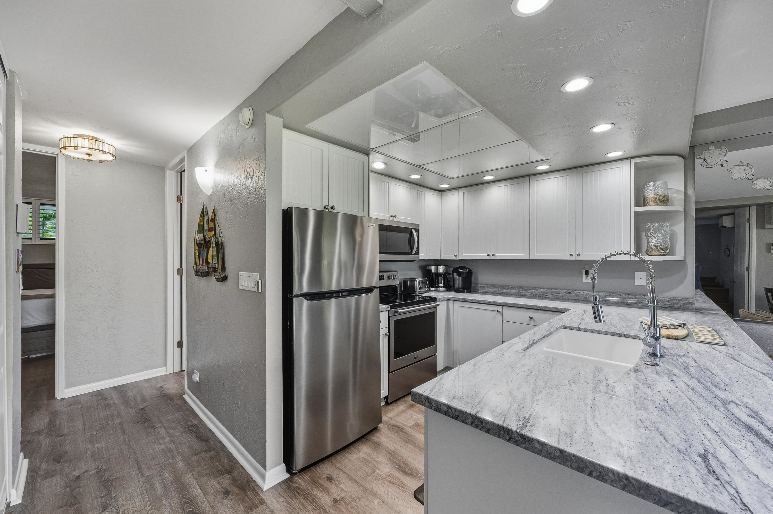 3543 Lower Honoapiilani Road, Unit H103 Lahaina, HI 96761 - Photo 5 of 50 a kitchen with kitchen island a counter top space a refrigerator and a sink