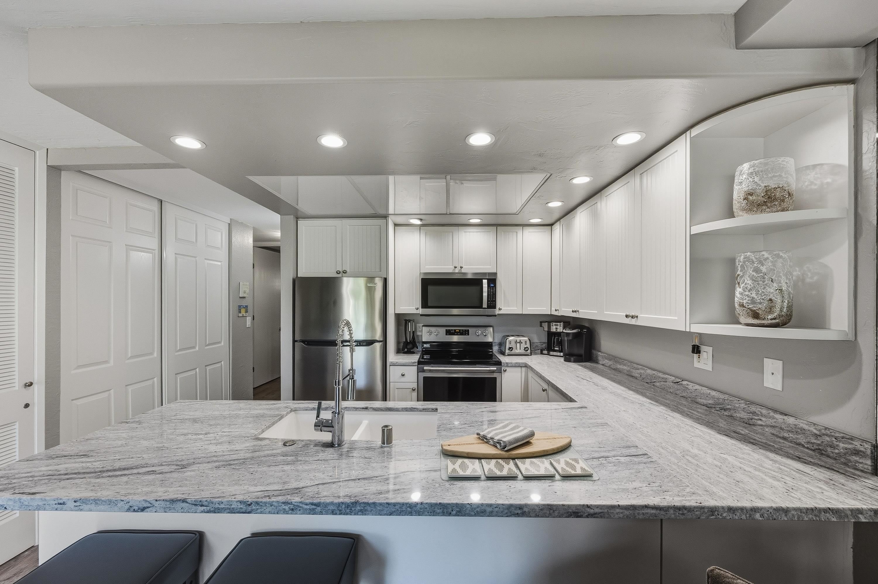 3543 Lower Honoapiilani Road, Unit H103 Lahaina, HI 96761 - Photo 7 of 50 a kitchen with counter top space cabinets and stainless steel appliances