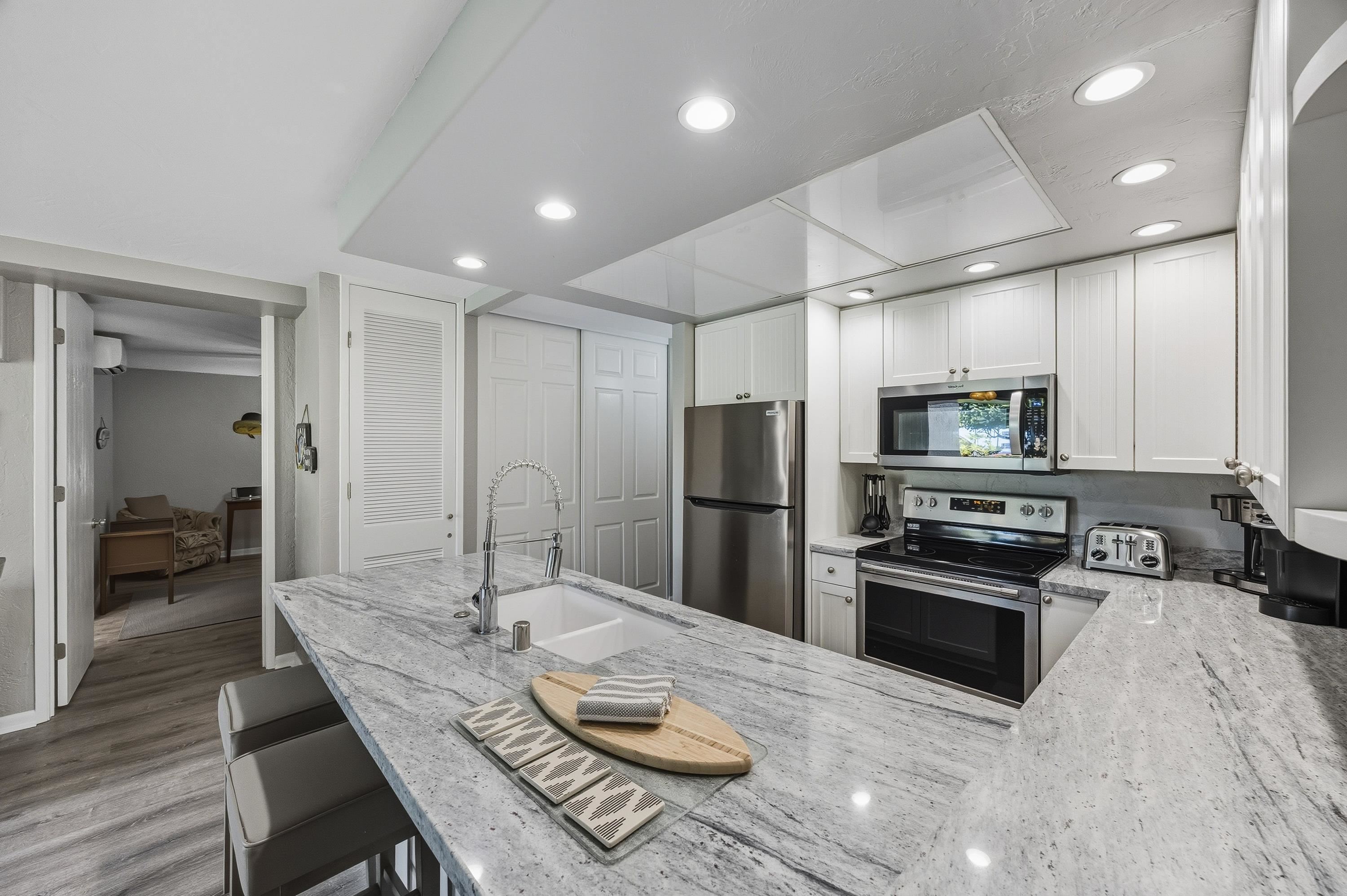 3543 Lower Honoapiilani Road, Unit H103 Lahaina, HI 96761 - Photo 8 of 50 a kitchen with refrigerator cabinets and wooden floor