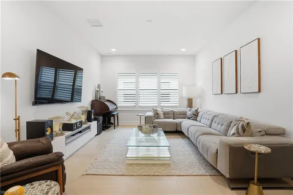 a living room with furniture wooden floor and a window