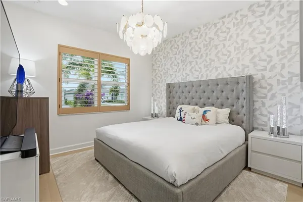 a bedroom with a bed and a chandelier