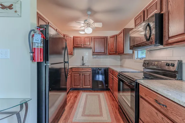 a kitchen with stainless steel appliances granite countertop a sink a stove a refrigerator and cabinets