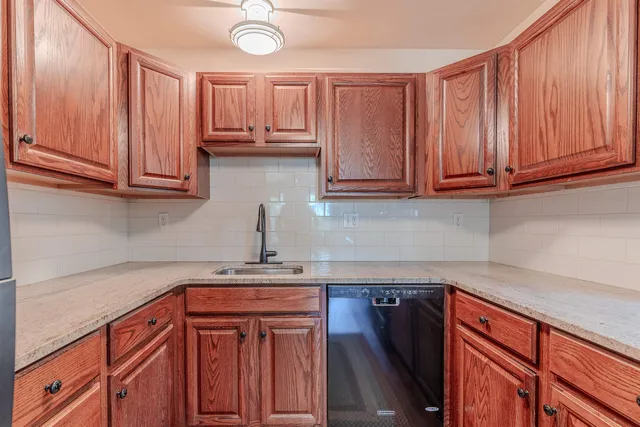 a kitchen with stainless steel appliances granite countertop wooden cabinets a sink and dishwasher