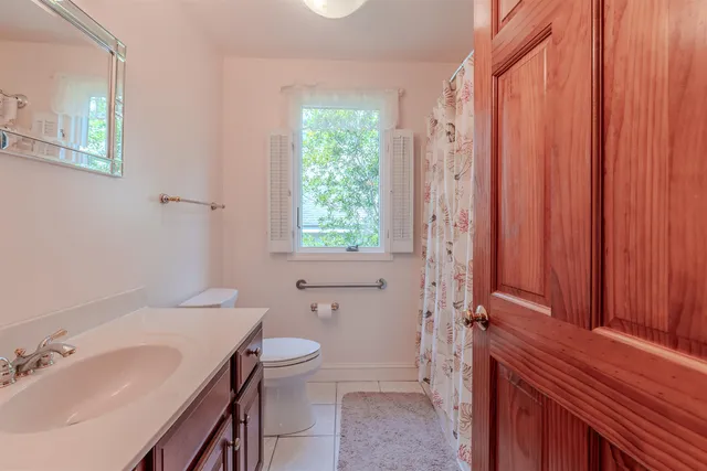 a bathroom with a sink a toilet and shower curtain