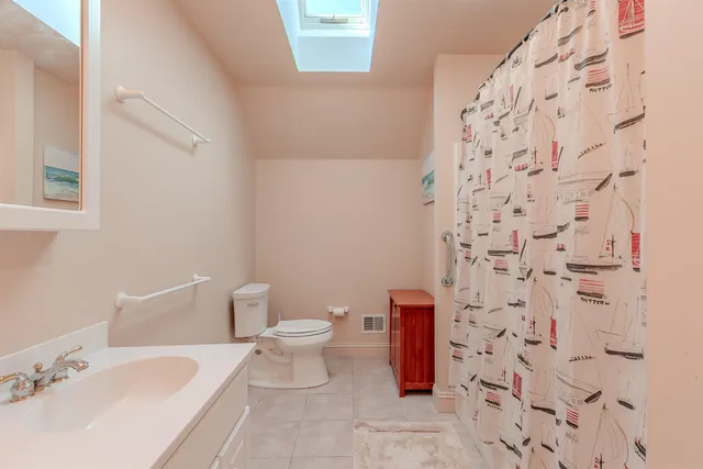 a white toilet sitting next to a bathroom sink