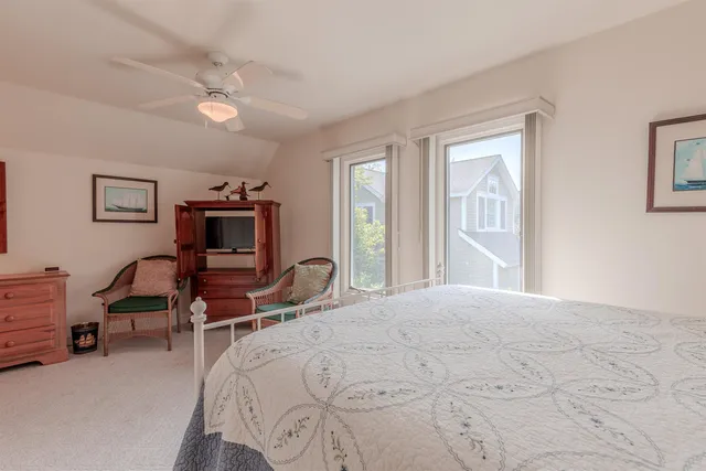 a bedroom with a bed a chair and a chandelier