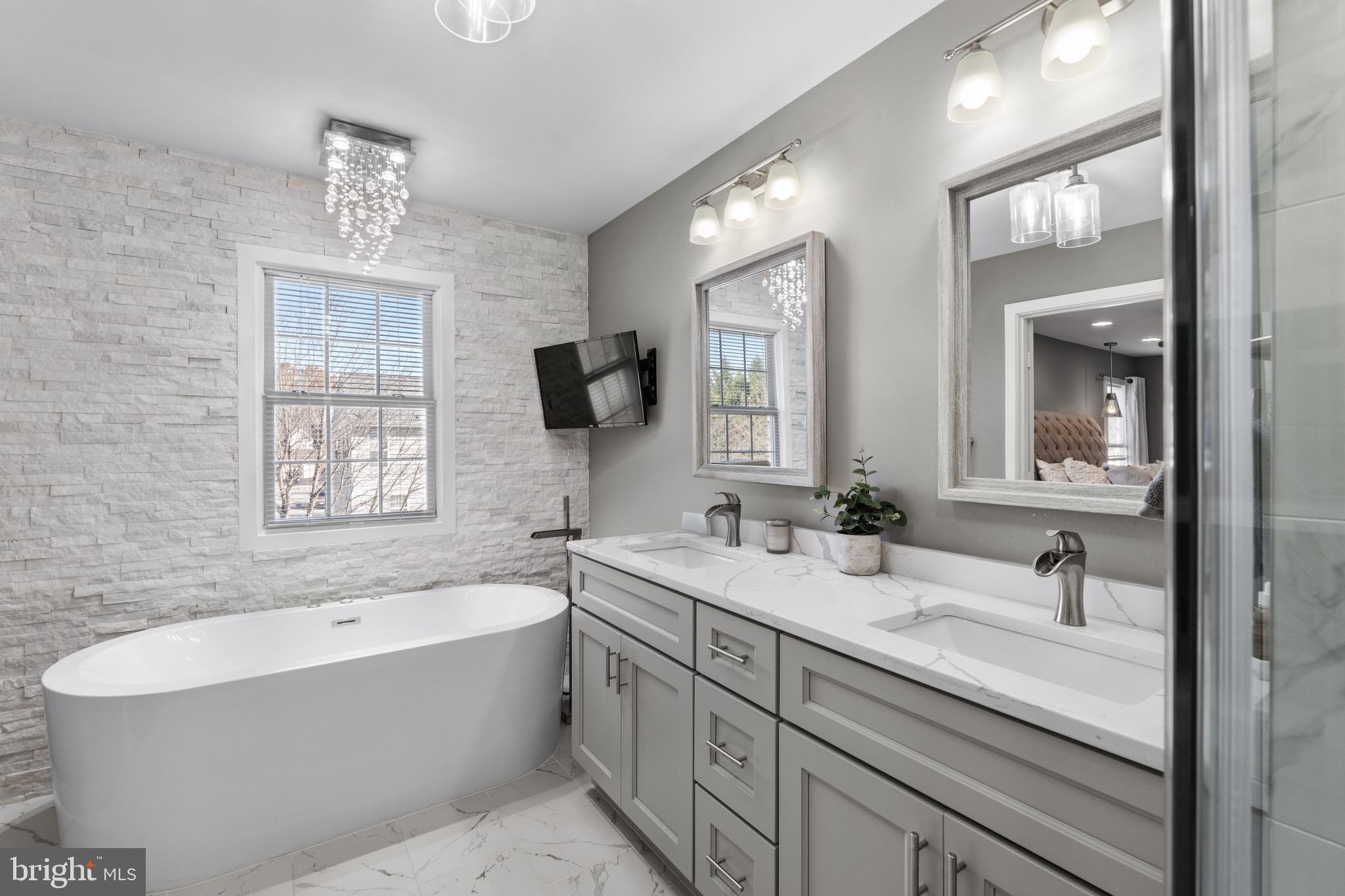 1735 Canal Run Drive Point of Rocks, MD 21777 - Photo 32 of 59 a bathroom with a bathtub a double vanity sink a window and a mirror