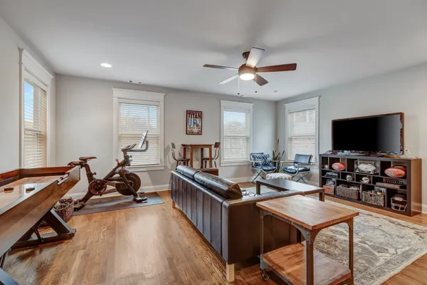 a living room with furniture flat screen tv and a large window