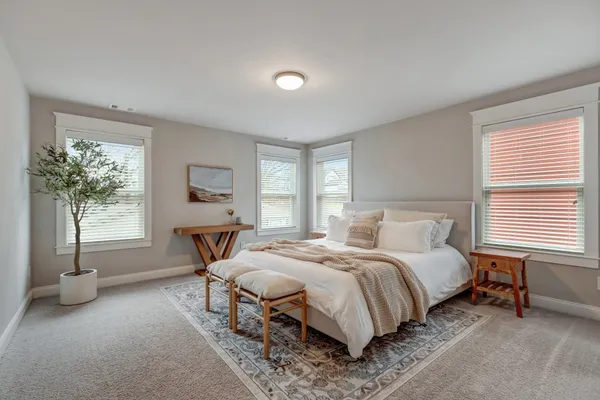 a bedroom with a bed and a large window