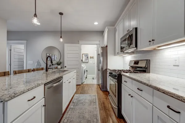 a kitchen with stainless steel appliances granite countertop a sink stove and refrigerator