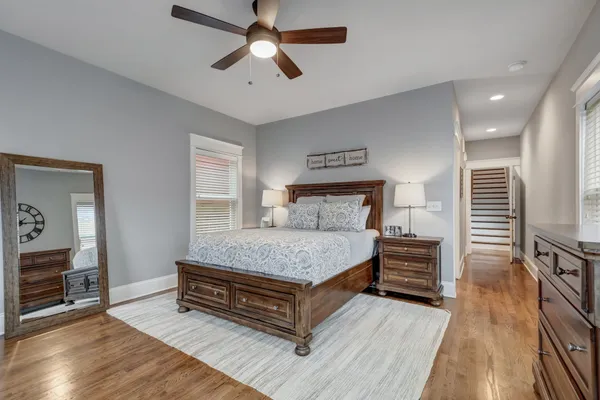 a bedroom with a bed dresser and a wooden floor