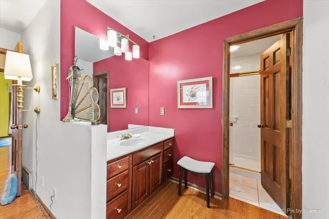 a bathroom with a sink a mirror a toilet and shower