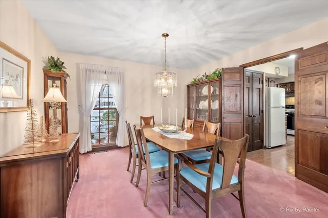 a dining room with furniture a chandelier and wooden floor