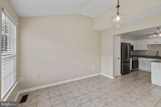 a view of kitchen with refrigerator and window