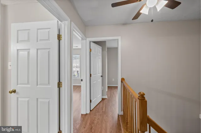 a view of a hallway with wooden floor and staircase