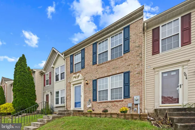 front view of a brick house with a yard