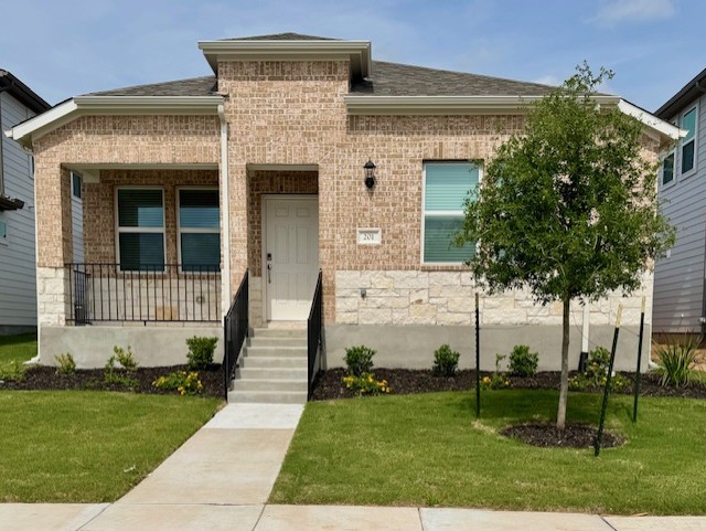 Brick and stone veneer exterior with a covered porch featuring black metal railings