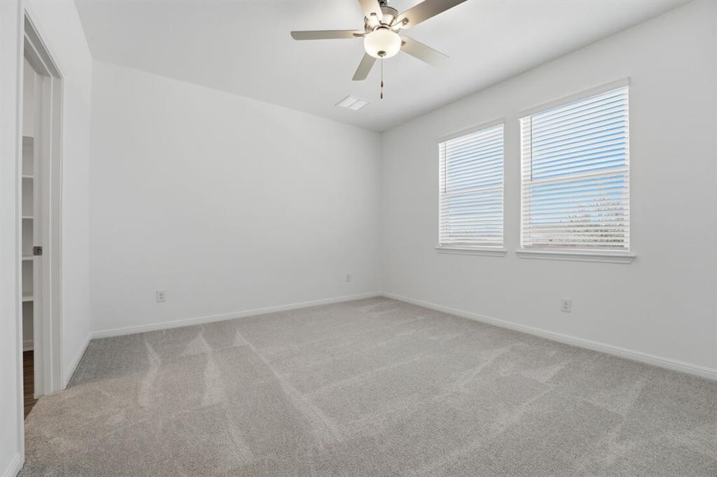 201 Betsy Road Hutto, TX 78634 - Photo 11 of 18 This room features light gray carpeting, two windows with blinds, and a ceiling fan with integrated lighting