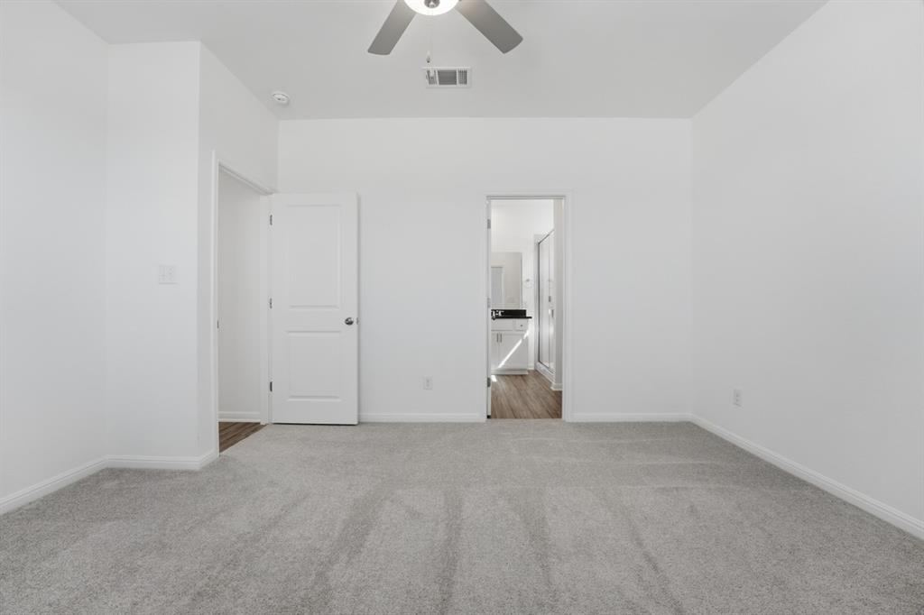 201 Betsy Road Hutto, TX 78634 - Photo 12 of 18 Spacious room featuring light gray carpeting, crisp white walls, and a ceiling fan