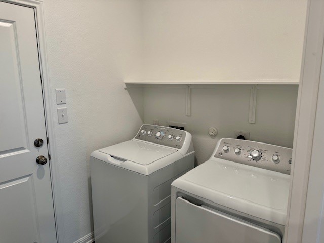 201 Betsy Road Hutto, TX 78634 - Photo 17 of 18 Laundry area featuring a washer and dryer, a white shelf, and a white door
